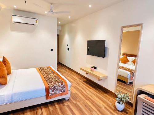 a hotel room with a bed and a tv at Hotel IP Swarn near Anand Vihar Vaishali Ghaziabad in Ghaziabad