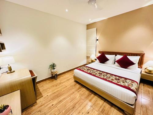 a bedroom with a large bed with red pillows at Hotel IP Swarn near Anand Vihar Vaishali Ghaziabad in Ghaziabad
