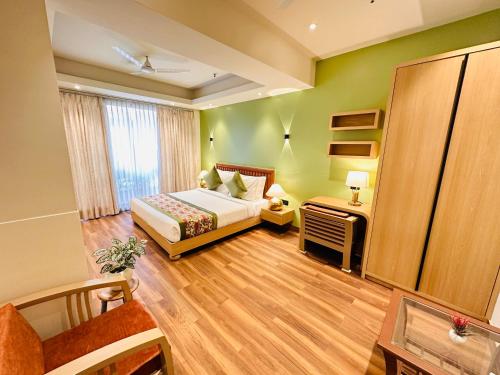 a bedroom with a bed and a desk and a window at Hotel IP Swarn near Anand Vihar Vaishali Ghaziabad in Ghaziabad