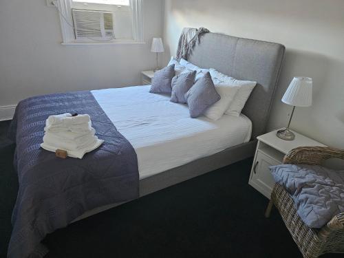 a bedroom with a bed with towels on it at Clubhouse Hotel Yass in Yass