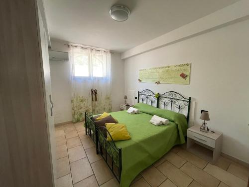 sypialnia z zielonym łóżkiem w pokoju w obiekcie B&B Francesca w mieście Scorrano