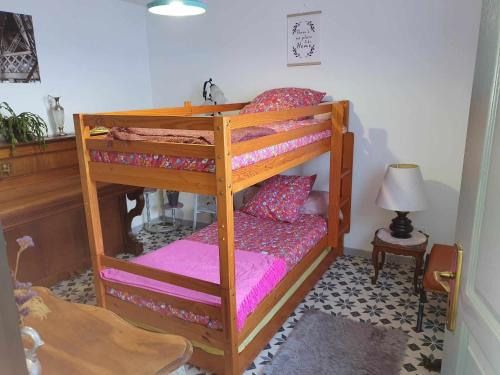 una camera con 2 letti a castello e lenzuola rosa di Chez Alain a Oye-Plage
