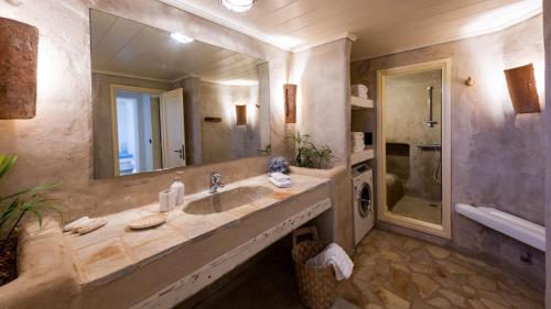 a bathroom with a sink and a large mirror at BLUE VILLA in Kampos Paros