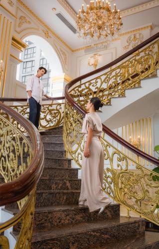a bride and groom walking down the stairs of a mansion at Paracel Beach Hotel in Da Nang