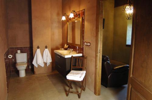 a bathroom with a sink and a toilet and a mirror at La Premsa Hotel Rural in Cardona