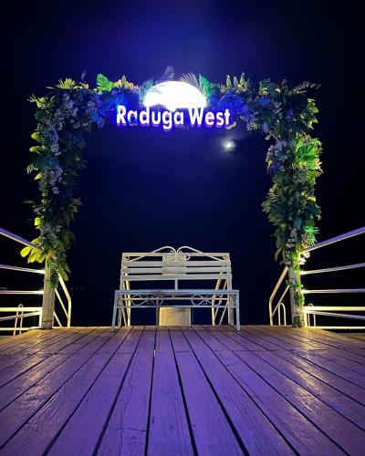 a bench on a stage with a sign that reads rabula west at Raduga West 'Pearl' Apartment in Koshkolʼ
