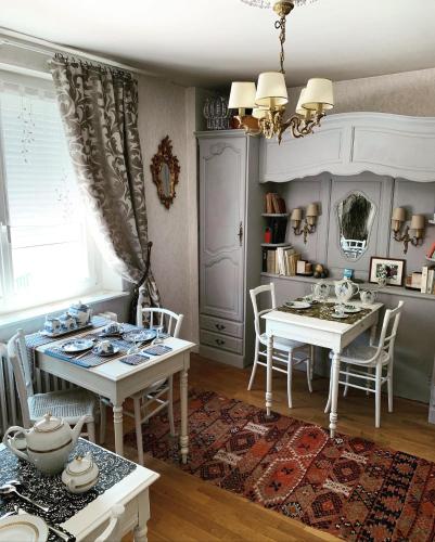 - une salle à manger avec deux tables, une table et des chaises dans l'établissement Les Garçonnières de Sologne, à Salbris
