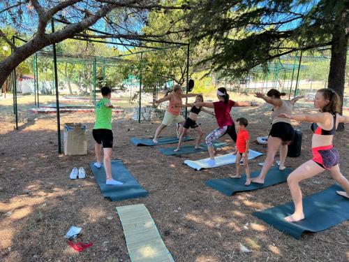 a group of people doing yoga in a park at Apartments Medena in Trogir