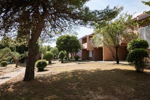 a house with a tree in a yard at Apartments Medena in Trogir