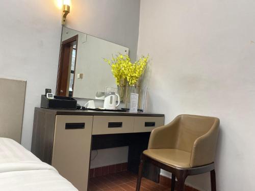 1 dormitorio con escritorio, espejo y silla en THE DREAMS HOTEL, en Douala