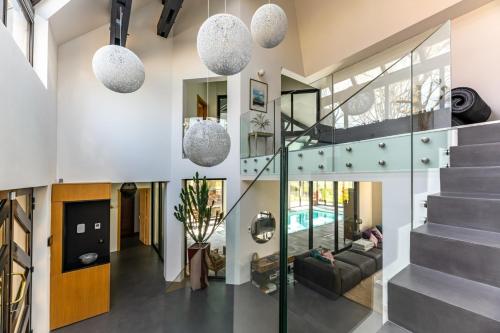 a living room with a staircase and glass walls at Villa d'architecte avec Piscine proche Paris in Rochefort-en-Yvelines