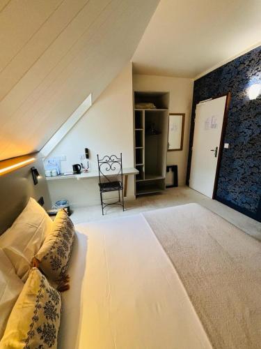 a bedroom with a large white bed in a attic at Castel Fleuri in Tours