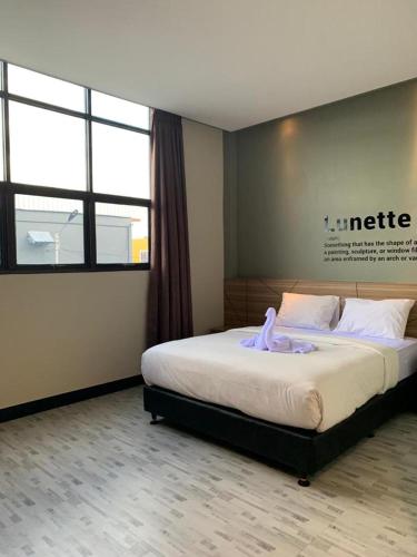 um quarto com uma cama com um roupão roxo em BLESS HOTELS em Sintang