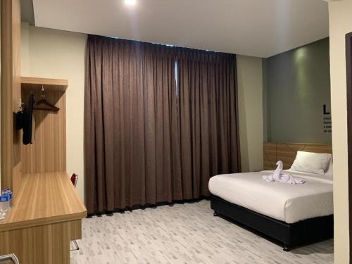 1 dormitorio con cama y ventana grande en BLESS HOTELS en Sintang