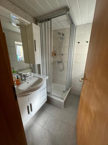 a white bathroom with a shower and a sink at Ewald von Holten in Bremerhaven