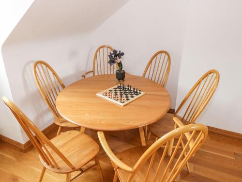 a wooden table with chairs and a chessboard on it at Doonalton House in Carrowmably