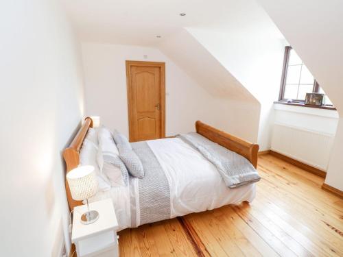a bedroom with a bed with a wooden headboard at Doonalton House in Carrowmably