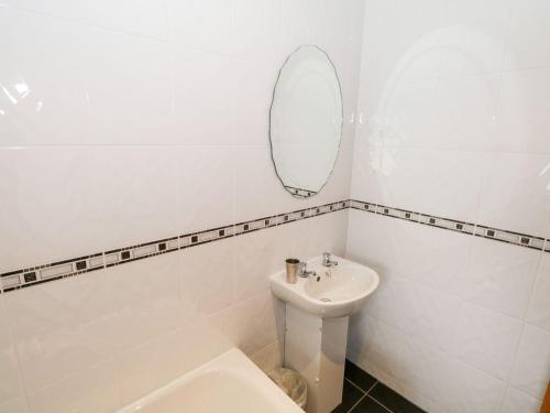 a white bathroom with a sink and a mirror at Doonalton House in Carrowmably