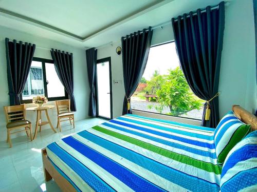 Schlafzimmer mit einem Bett mit blauen und grünen Streifen in der Unterkunft Hotel Cù Lao 3 (TiTi) in Tây Ninh