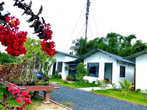 una casa con flores rojas y un banco frente a ella en Hotel Cù Lao 3 (TiTi), en Tây Ninh