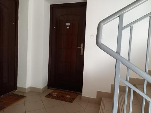 un corridoio con una porta nera e una scala di Mimi Apartman a Szeged