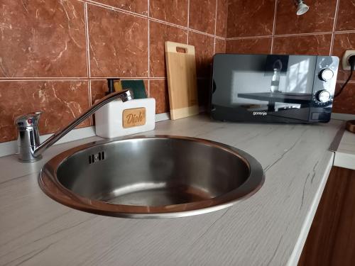 a kitchen counter with a sink and a tv at Mimi Apartman in Szeged