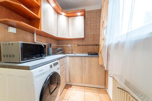 a kitchen with a washing machine and a sink at Comfort 28 B in Miskolc