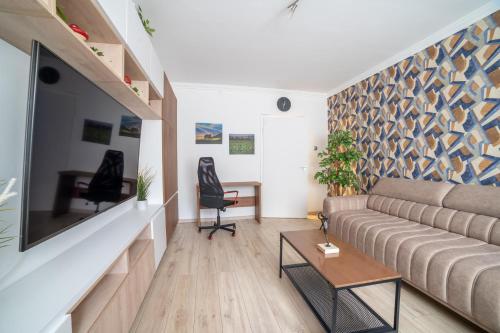 ein Wohnzimmer mit einem Sofa und einem Flachbild-TV in der Unterkunft Comfort 28 B in Miskolc