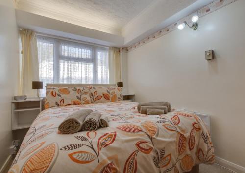 a bedroom with a bed with a comforter and a window at 3A Strandways in Saundersfoot