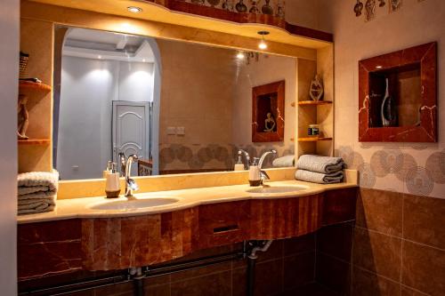 a bathroom with two sinks and a large mirror at Elegant Garden & 2Living Areas, 2 Bed Rooms for 6 Guests in Umm al ‘Amad