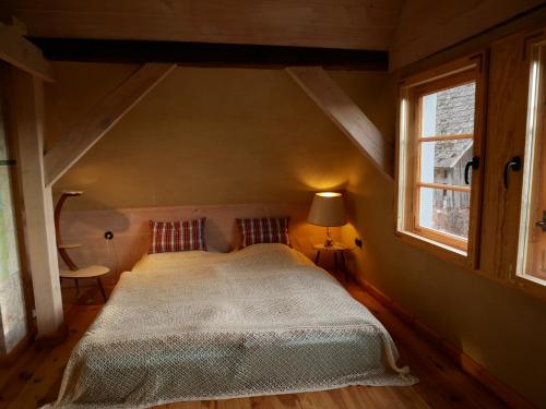 a bedroom with a large bed in a attic at Przytulny dom z kominkiem in Woldenberg Neumark