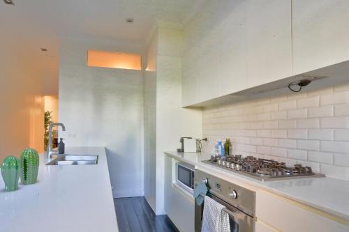 a kitchen with a stove top oven next to a counter at Spacious 3 Bedroom House Glebe with 2 E-Bikes Included in Sydney