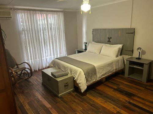 a bedroom with a large bed and a window at Oudam Overnight Accomodation in Bloemfontein