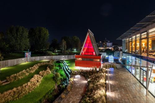 a building with a red pyramid next to a garden at Thermenhotel Gesundheits-Bad Buchau in Bad Buchau