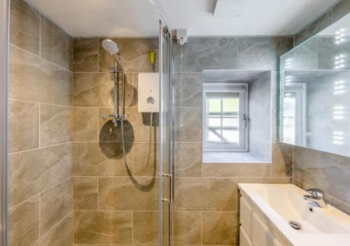 uma casa de banho com um chuveiro e um lavatório. em Y Nyth em Cerrig-y-Druidion