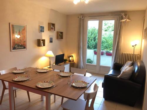 un salon avec une table et une salle à manger dans l'établissement Toussaint by Yumē, à Toulouse