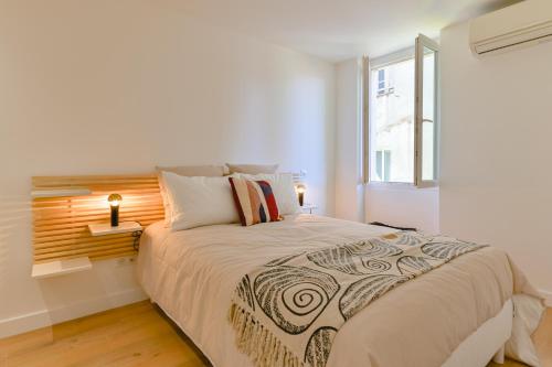 une chambre avec un grand lit et une fenêtre dans l'établissement Appartement chic & chaleureux - cœur de ville, à Ajaccio