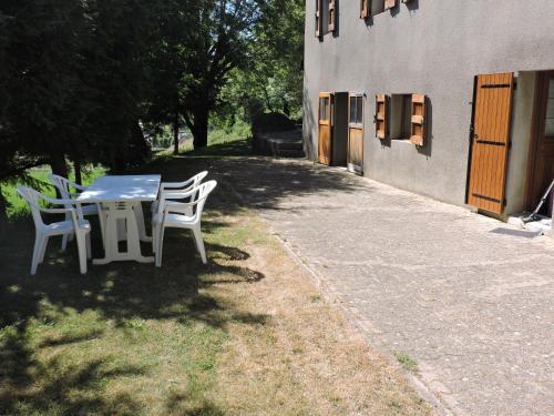 Mas-dʼOrcières的住宿－Gite au pied du mont Lozère 1，桌子和椅子坐在大楼旁边