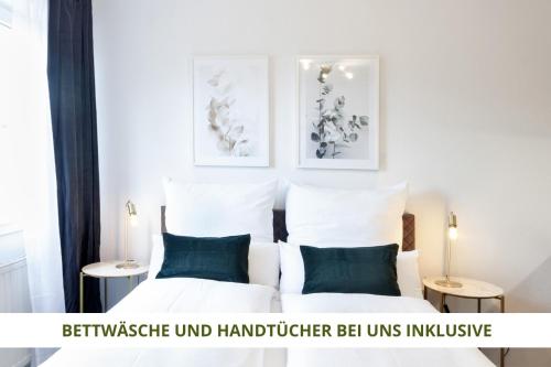 um quarto com uma cama com lençóis brancos e almofadas azuis em Apartment Wahnfried No5 - zentrales Cityapartment Küche mit Duschbad - 300m zur Fussgängerzone em Bayreuth