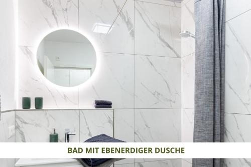 Baño blanco con espejo y lavabo en Apartment Wahnfried No5 - zentrales Cityapartment Küche mit Duschbad - 300m zur Fussgängerzone, en Bayreuth