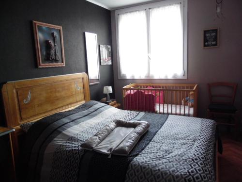 een slaapkamer met een bed met een zwart-witte deken bij appartement pour famille amis ou colègue in Cholet