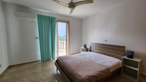een slaapkamer met een bed en een groot raam bij 2-bedroom Villa with private pool in Anarita Paphos in Anarita