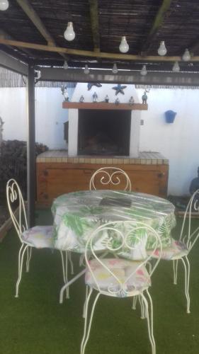 mesa con 2 sillas y chimenea en Maison avec piscine à Aigues Mortes, en Le Grau-du-Roi