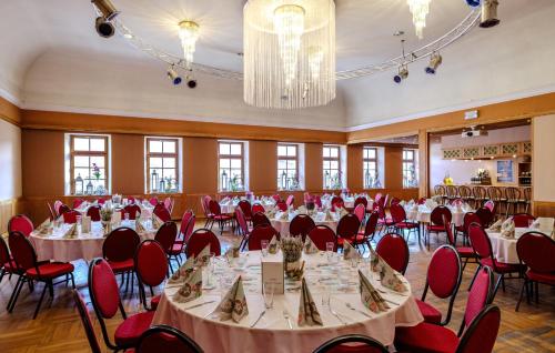 a banquet hall with tables and red chairs at Flair Hotel Kamenz in Kamenz