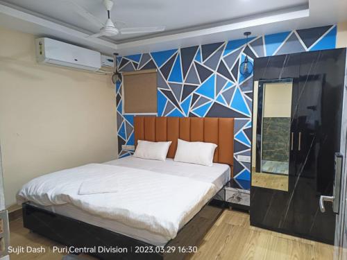 a bedroom with a bed with a mural on the wall at Hotel Santosh Inn Puri - Jagannath Temple - Lift Available - Fully Air Conditioned in Puri