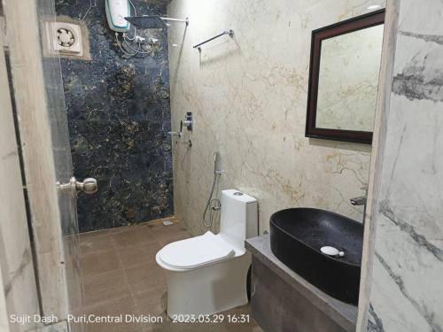 y baño con aseo, lavabo y ducha. en Hotel Santosh Inn Puri - Jagannath Temple - Lift Available - Fully Air Conditioned en Puri