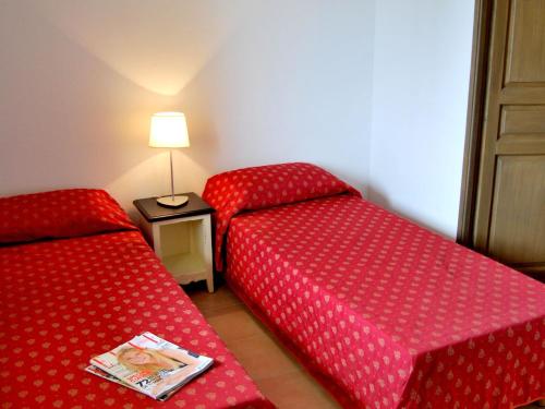 une chambre avec deux lits et une table avec une lampe dans l'établissement Apartment in La Closerie with Terrace, à Barjac