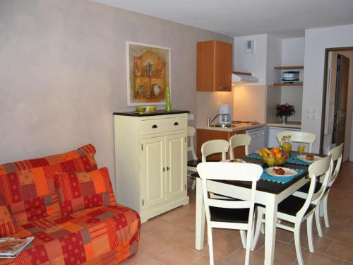 une cuisine et un salon avec une table et des chaises dans l'établissement Apartment in La Closerie with Terrace, à Barjac