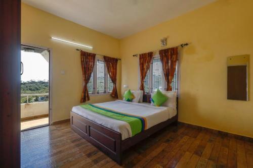 sypialnia z dużym łóżkiem z zielonymi poduszkami w obiekcie STARLIGHT HOTELS KODAI w mieście Kodaikānāl