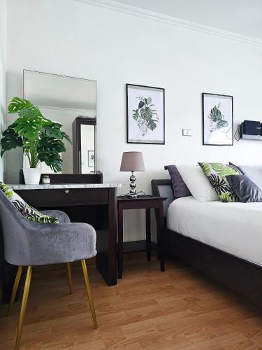 a bedroom with a bed and a desk and a chair at Patong Tower Apartment in Patong Beach